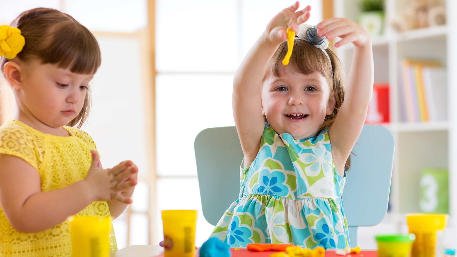 Two cute kids are playing with clay